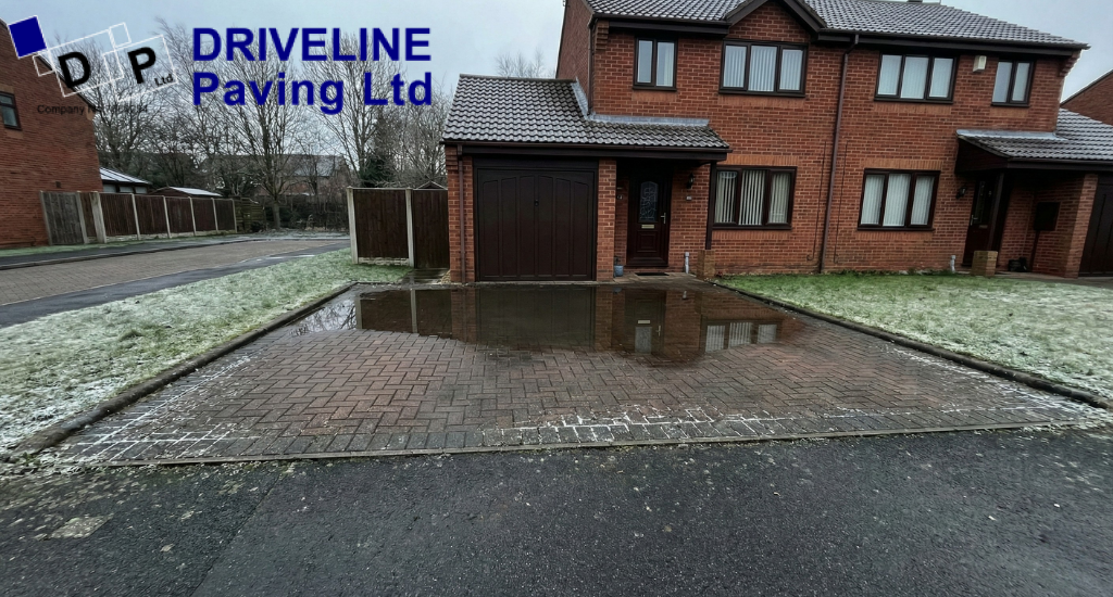 Standing water near the house is a common sign that driveway drainage is struggling during winter conditions.