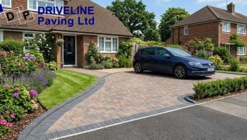 block paved driveway in epping with clear contrasting edging beside a lawn and planted border on a bright summer day