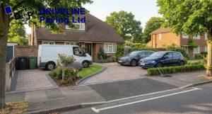 delivery van and family cars parked on a woodford block paving driveway in summer