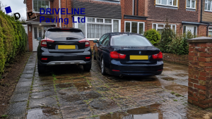 neglected driveway with puddles and moss